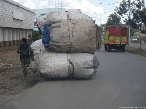 This is a human powered cart full of plastic containers, etc. You can see the second in command running alongside.