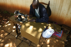 This is Pascal, the tailor, who does his business al fresco, making canvas curtains for the windows in the truck shell.