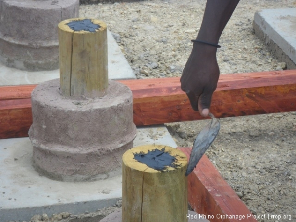 Each of the pine peelers, set in colored concrete gets a dab of bitumin (we call it black jack)