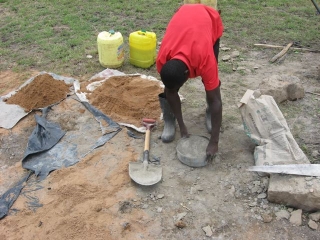 A container full of cement to go with the four of sand on the plastic sheet.