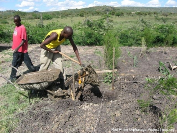 Gilbert dug the 24\'x24\"x30\" holes at the corners of the rectangle in the rock hard black cotton soil. We shot all the  levels, and then poured a nine inch reinforced foundation in each hole.