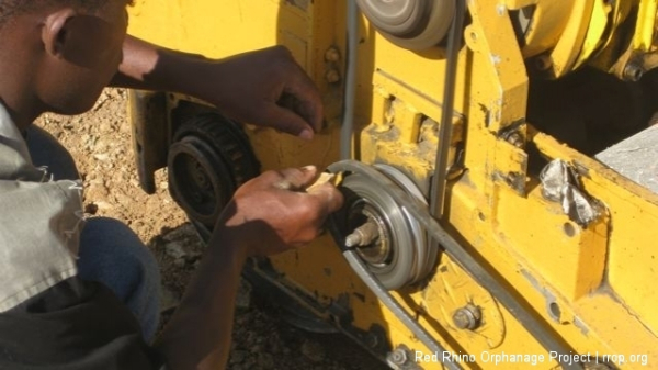 Ben putting on the belt that made the machine vibrate. He just did it while the wheels were running.