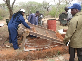 Putting the dirt (murram) through a sieve.