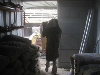 One of the monks stacking the 110 pound sacks in our container.