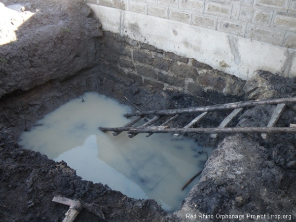 This excavation for a quarried stone stand for two 1500 liter water tanks near the kitchen seemed harmless enough. 12' by 9' by 5' and down to the murram. But it has been raining here now almost everyday and water has been trickling in from several small underground rivulets