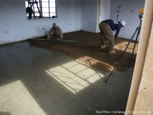 Laying down the two inches of mortar in the great room. All under the watchful eye of the site level.