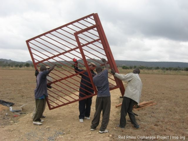 We brought the gate to its new and permanent home. Then we muscled up and lifted the two sides into place, over the long rebar which we had extended to go deep into the hollow 4x4\" post,