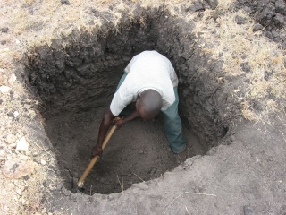Moses working on the one meter square, four foot deep holes we dug for each post.