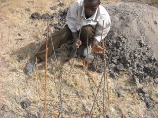 Gilbert putting together the rebar reinforcements for the gate post\'s foundations.