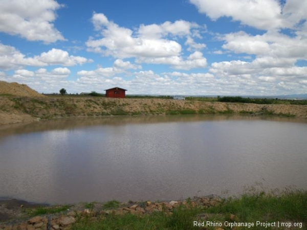 Now were standing on the dam, just above the spillway, looking back across to Gilbert's new house and the murram pile.