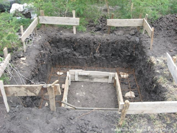 and we give over fully to the excavation urge, and the necessity of black cotton soil removal. The square of lumber in the middle is the foundation form, the outside being the earthen wall, and the rebar runners are snug in their beds.