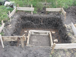 and we give over fully to the excavation urge, and the necessity of black cotton soil removal. The square of lumber in the middle is the foundation form, the outside being the earthen wall, and the rebar runners are snug in their beds.