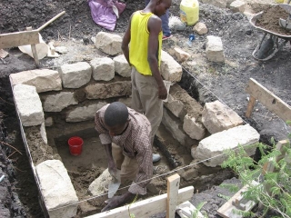 With the exact corners set by the site level and the string markers from the batter boards, Moses and Murafu laid in the first course of stones with the mortar, a 3 to 1 mixture of sand and cement, and followed the string\'s leading for the subsequent five.